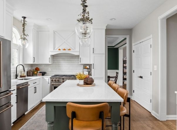 A kitchen with white cabinets and a large island.
