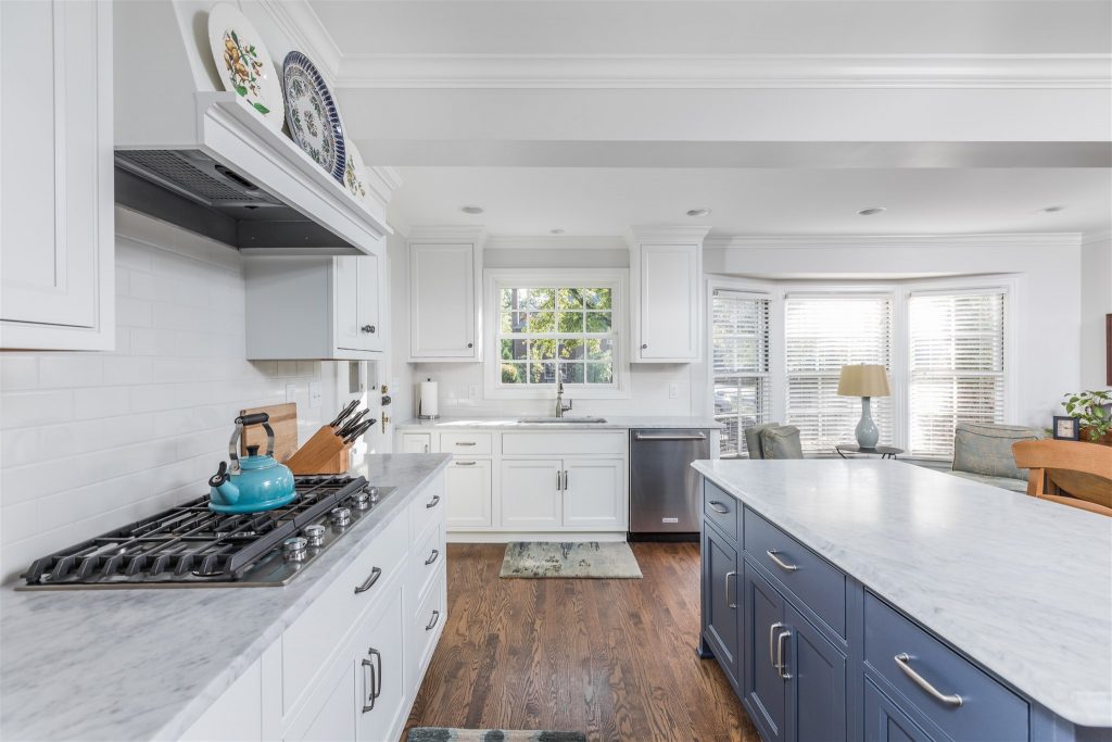 the support beam shows where the old kitchen ended. it now leads into a sunny eating area | cape cod kitchen; whole house makeover