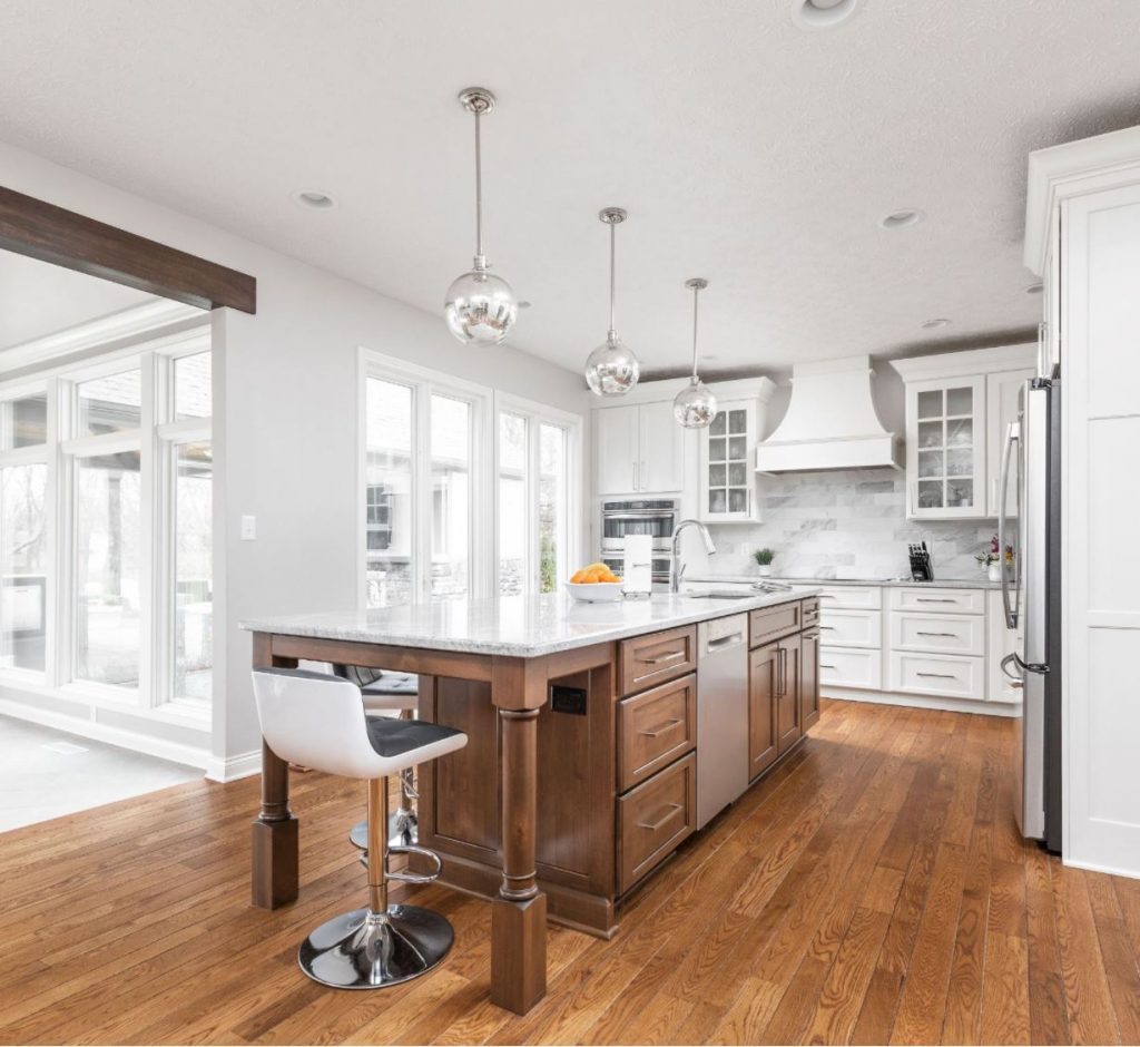 this bright and open kitchen has a large island that provides ample room for meal prep, entertaining and seating