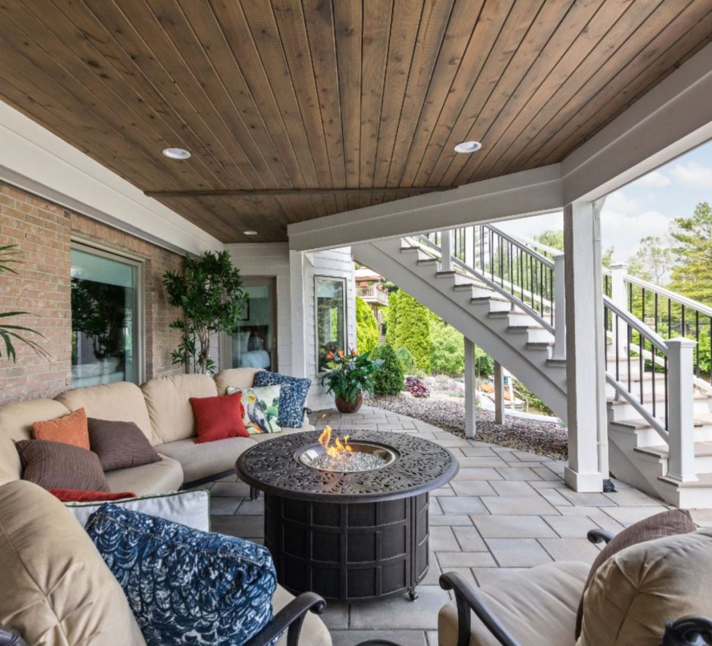 this outdoor seating area sits below the deck and looks out onto the water