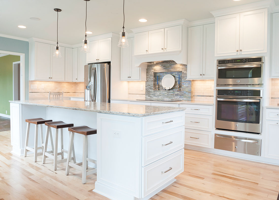 Completed Noblesville kitchen remodel with white cabinetry, a large island and views of the White River