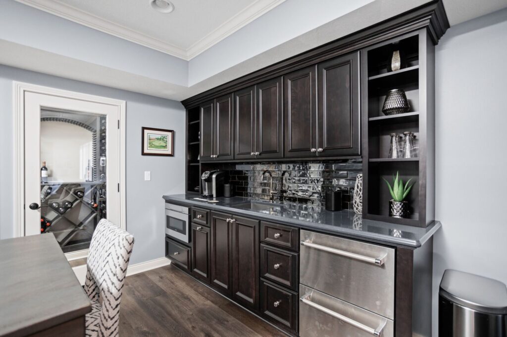 wet bar with gray cabinetry in an indianapolis home