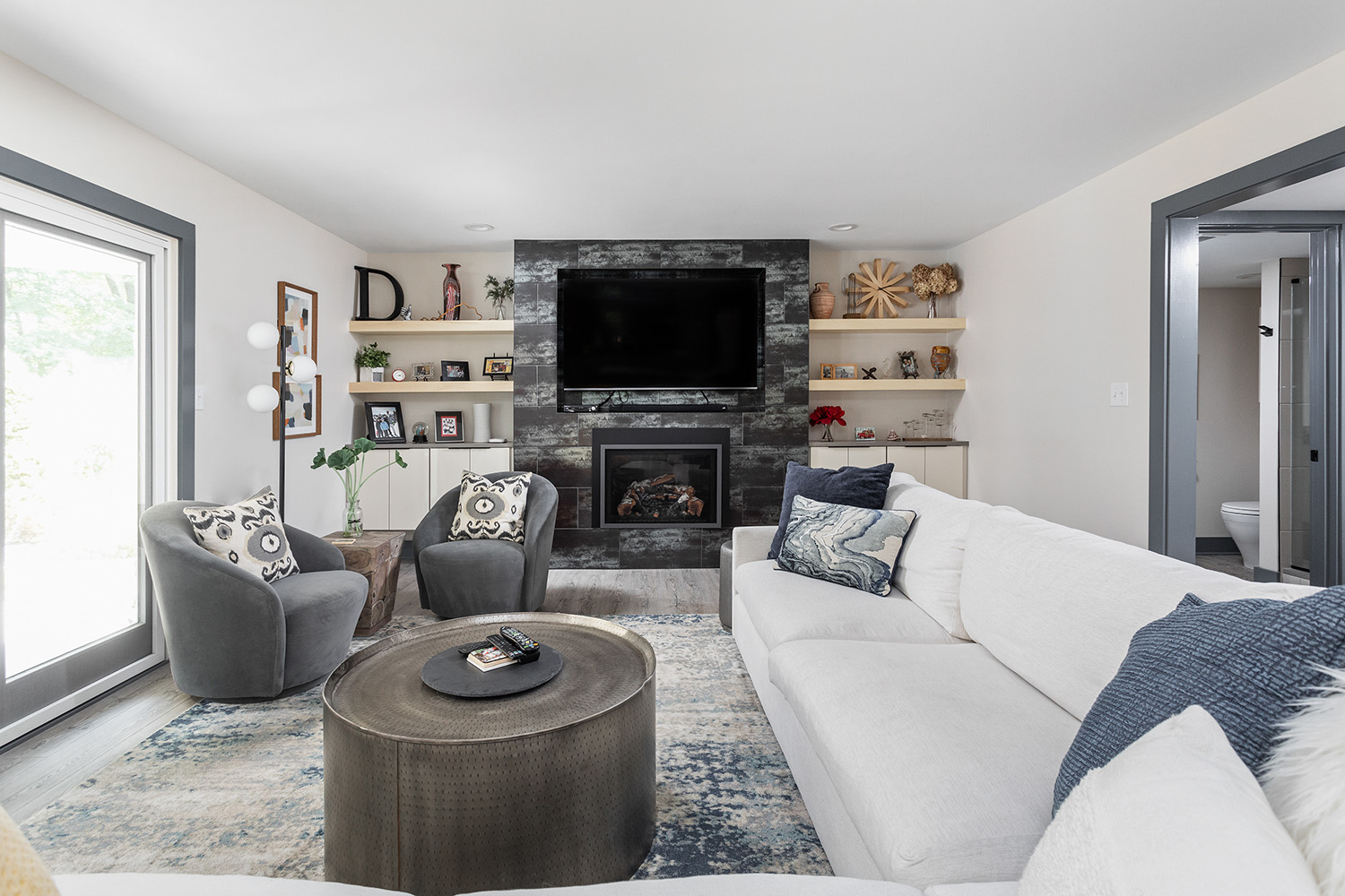 Remodeled living room with a fireplace, built-in shelving and comfortable seating