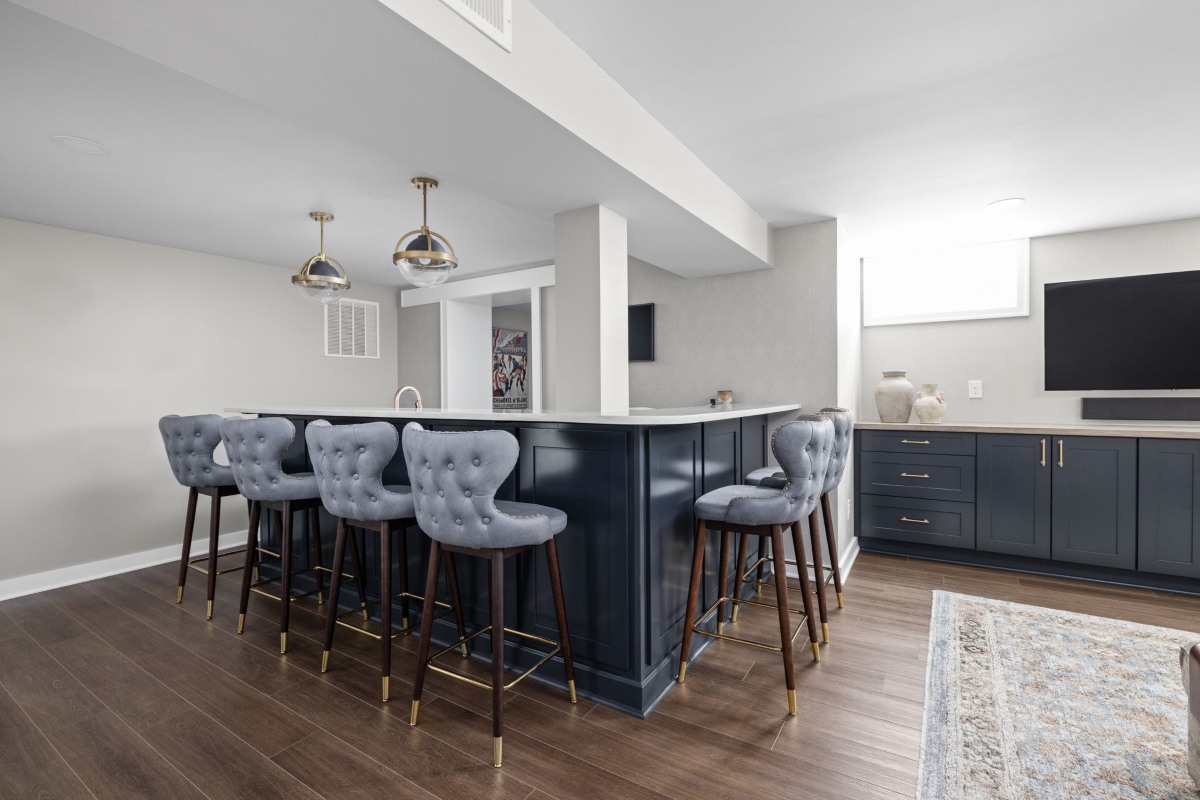 Dark basement bar with seating and built-in cabinetry in a Meridian-Kessler home remodel