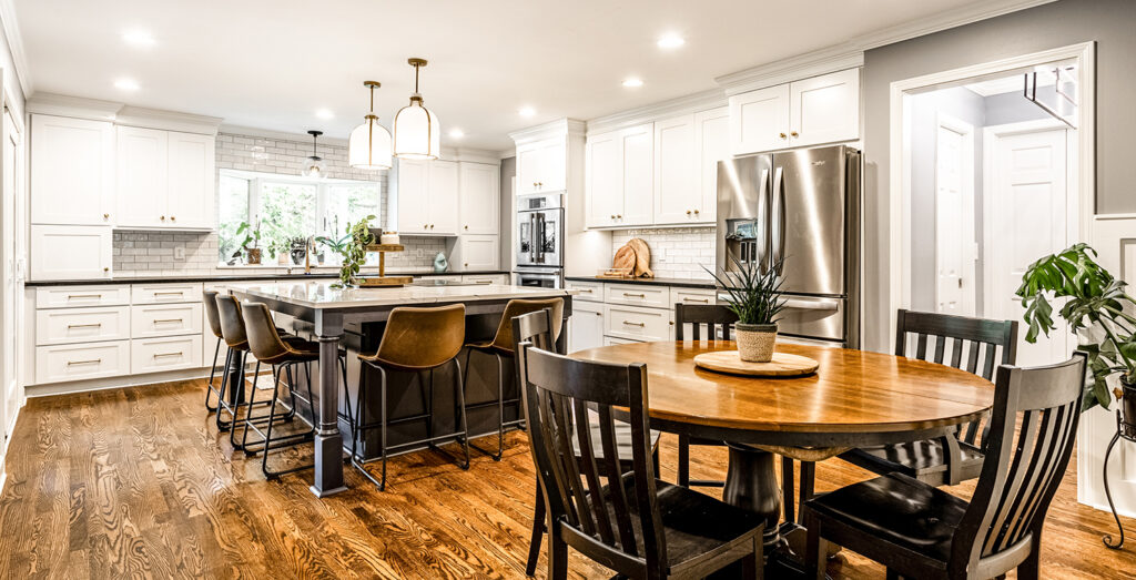 Kitchen remodel in Indianapolis with custom cabinetry, a stained wood primary island, polished countertops, layered lighting, and coordinated pantry, wet bar, and laundry room spaces in a cohesive whole home design