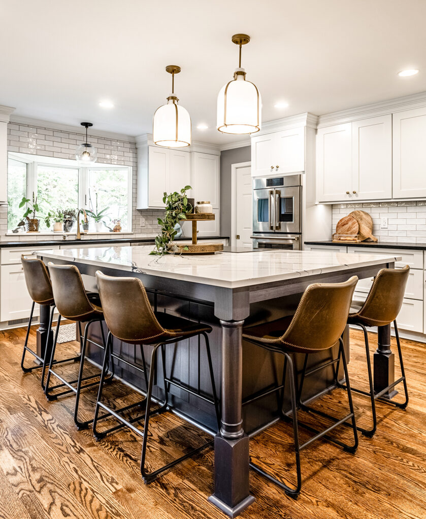 Kitchen remodel in Indianapolis with custom cabinetry, a stained wood primary island, polished countertops, layered lighting, and coordinated pantry, wet bar, and laundry room spaces in a cohesive whole home design