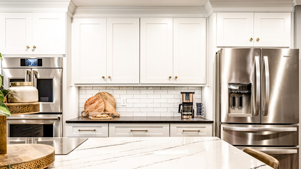 Custom kitchen remodel in Indianapolis with painted cabinetry, stained wood primary island, decorative backsplash, and layered lighting