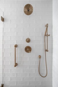 A Carmel, IN Bathroom Renovation picture showing walk-in shower. Complete with white tiles and matte brass fixtures.