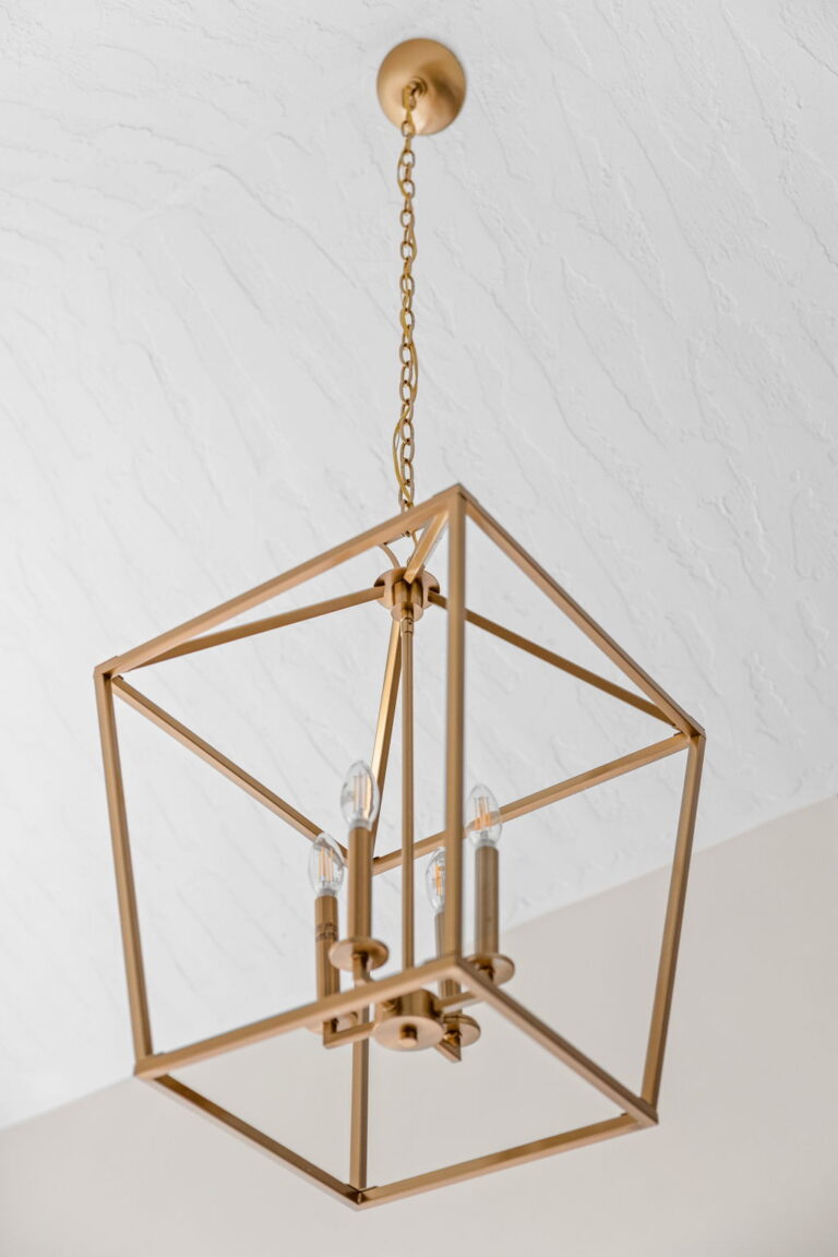 A Carmel, IN Bathroom Renovation picture showing the detail of the matte brass lighting pendant.