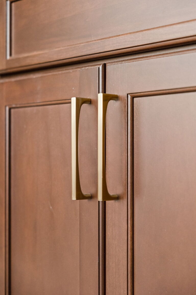 A Carmel, IN Bathroom Renovation picture showing the detail of the rich wood stained drawer with matte brass pull hardware.