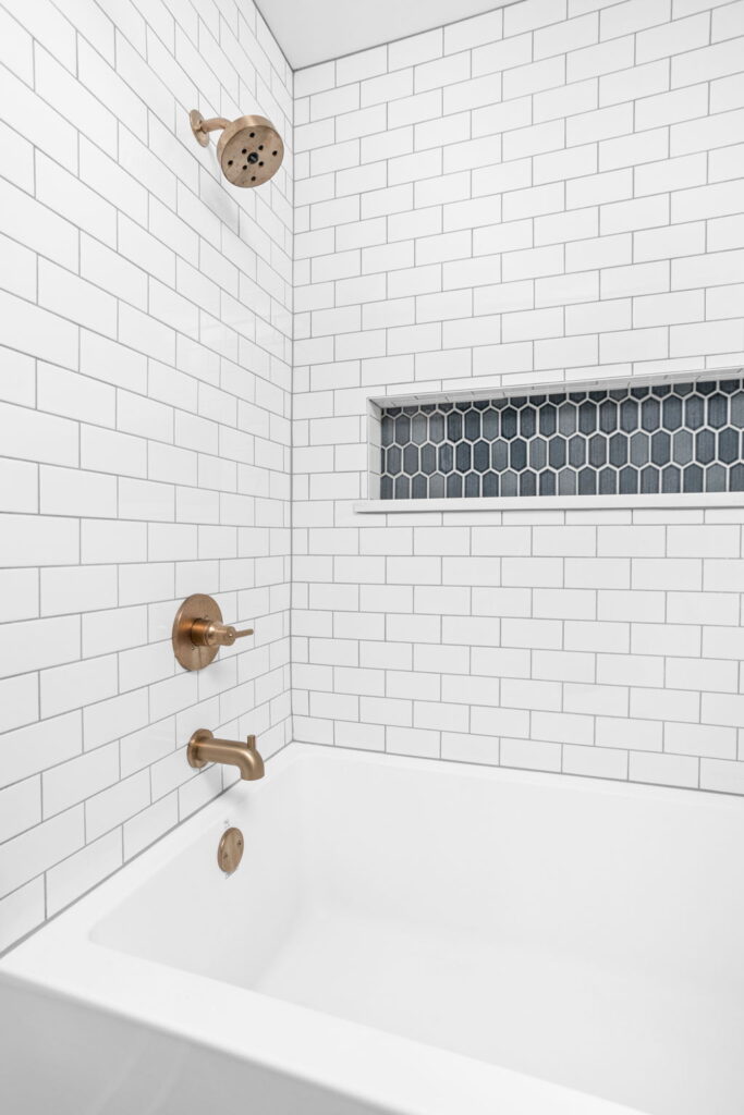 bathroom remodel with white tiles and gold tub fixtures