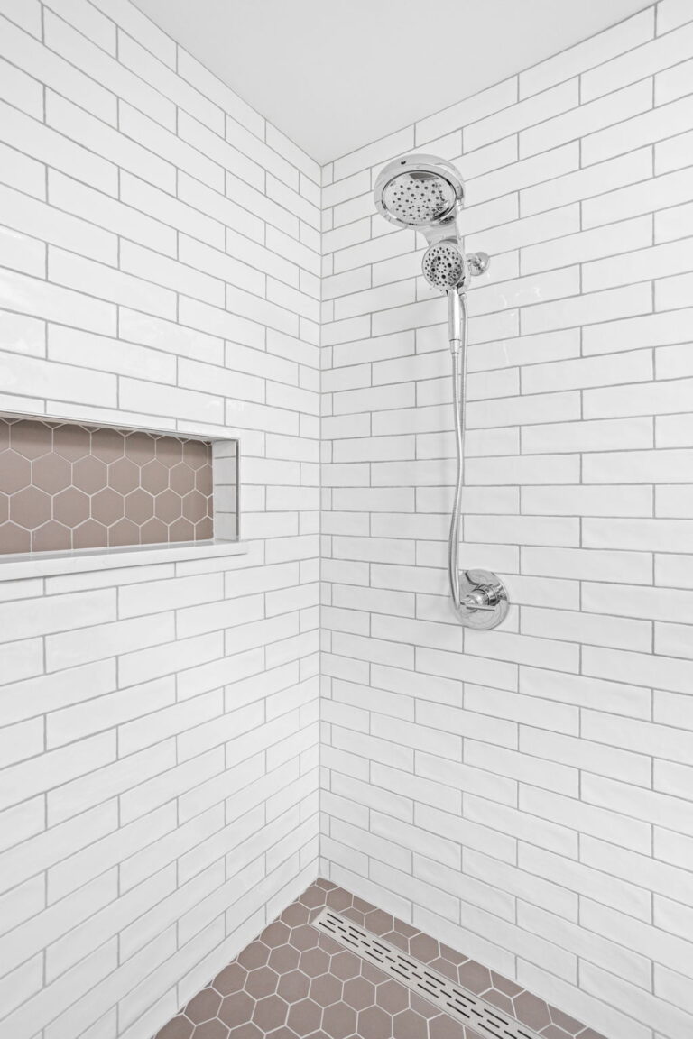 shower renovation in a bathroom with white and tan tiles