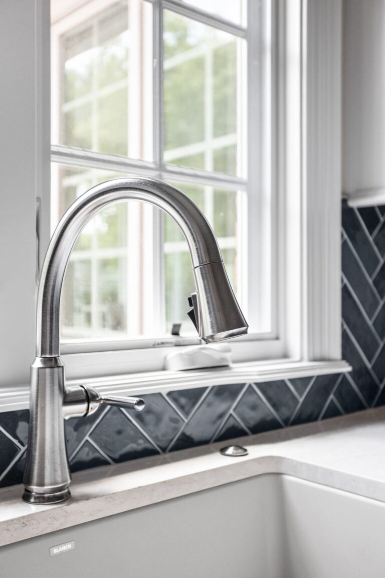 Carmel kitchen renovation refresh featuring refinished cabinetry, new buffet, bold tile, and timeless upgrades by Worthington Design & Remodeling. Photo shows close up of sink faucet in brushed nickel.