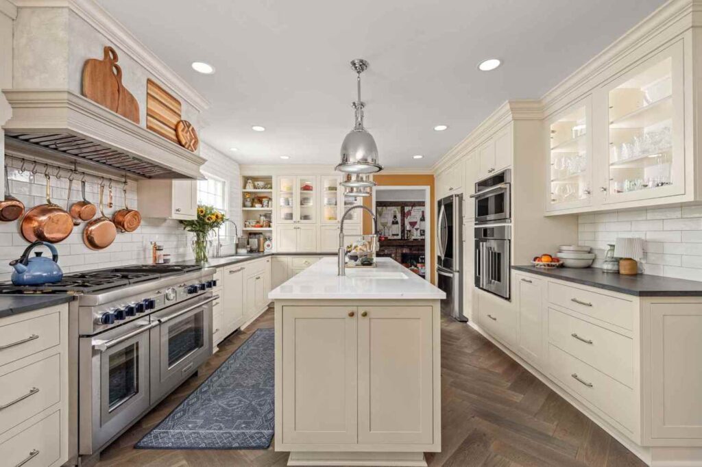Wide view of an Indianapolis kitchen and bath remodel showcasing double islands, warm cabinetry, and copper accents.