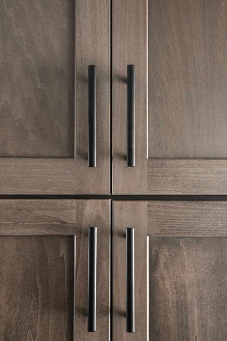 Close up of shaker style mudroom cabinet doors with long black pulls showcasing custom storage details in a Zionsville IN main level remodel.