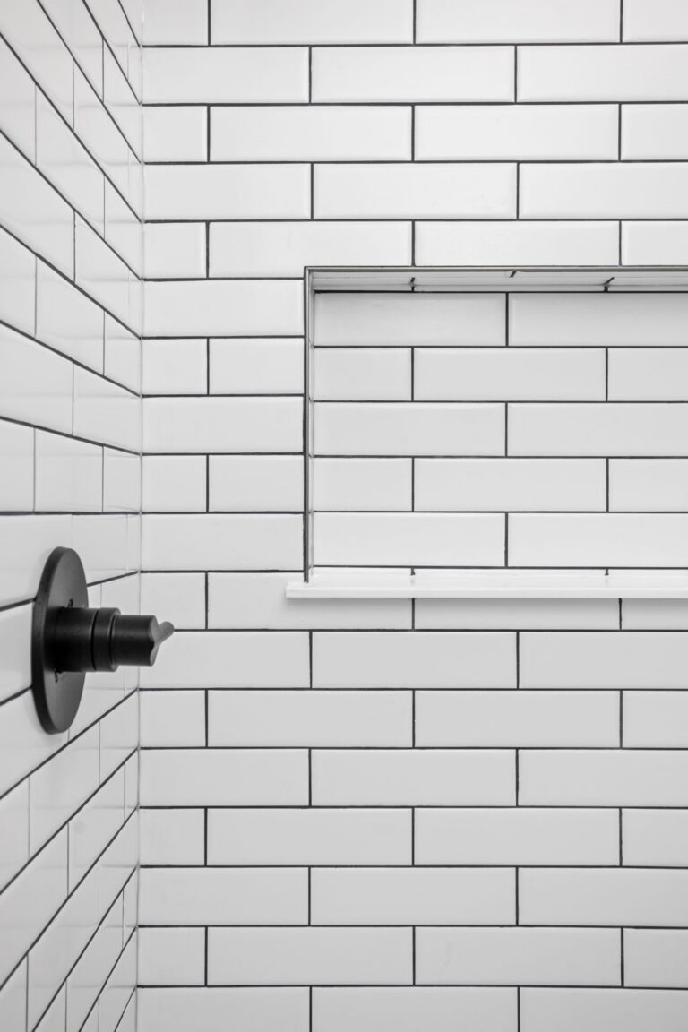 White subway tile shower detail in a Carmel IN basement renovation with clean grout lines and built-in niche.