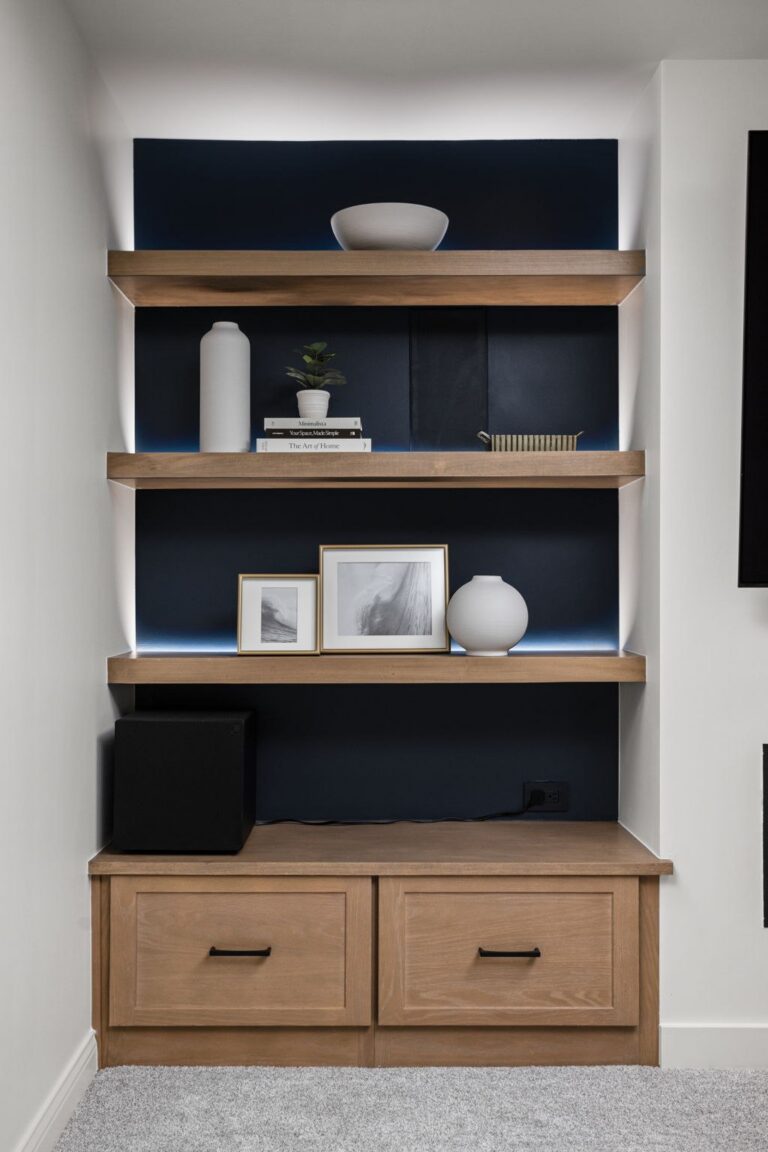 Built-in open shelving with integrated LED lighting in a Carmel IN basement living space.