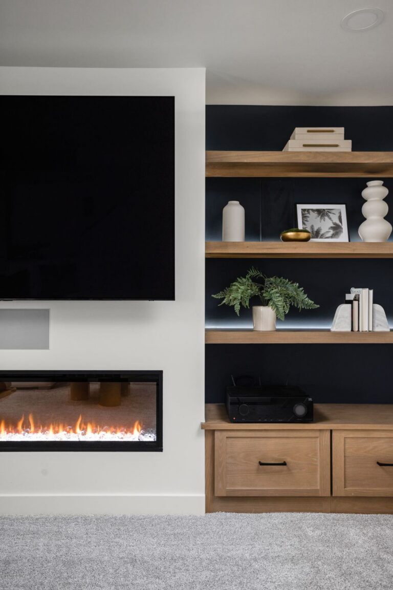 Basement media wall in Carmel IN featuring custom cabinetry, floating shelves, and a linear fireplace.