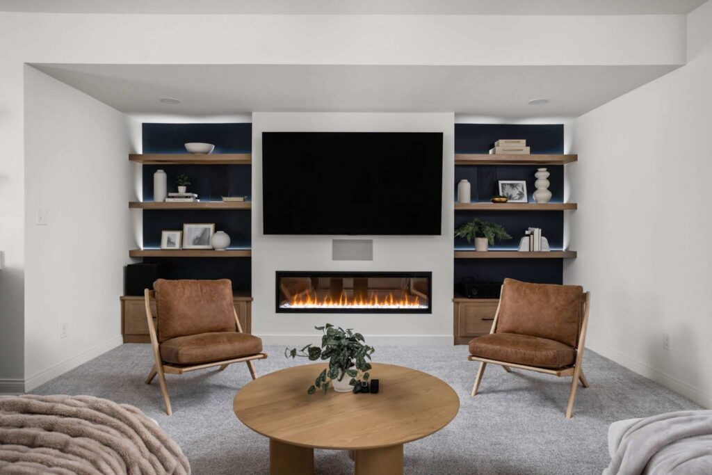 Custom entertainment center with fireplace in a finished Carmel basement featuring built-in shelving, warm wood tones, and cozy seating.