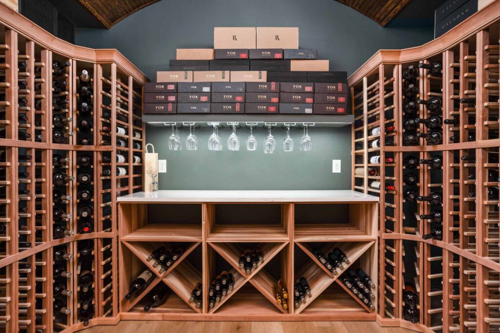 Custom wine cellar in a Carmel, Indiana basement remodel featuring built in wine racks, a quartz serving counter, accent lighting, and climate control planning by Worthington Design and Remodeling