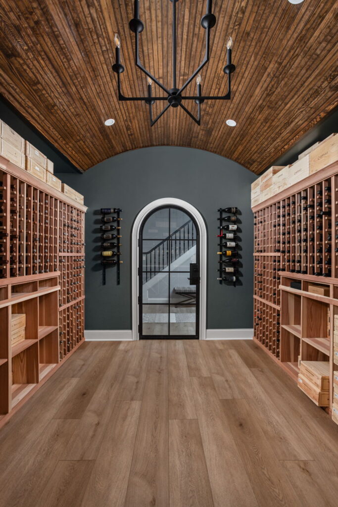 Custom wine cellar in a Carmel, Indiana basement remodel featuring built in wine racks, a quartz serving counter, accent lighting, and climate control planning by Worthington Design and Remodeling