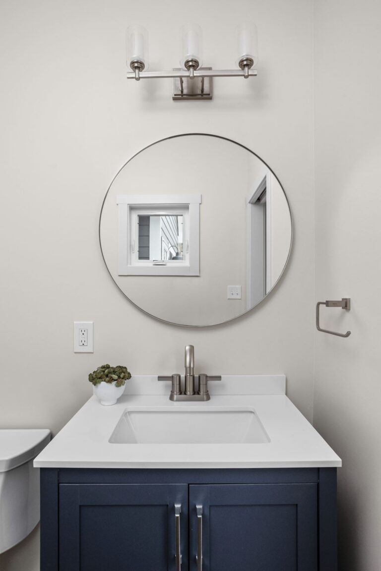 Half bath detail with vanity, faucet, mirror, and wall sconce lighting, four season room addition.