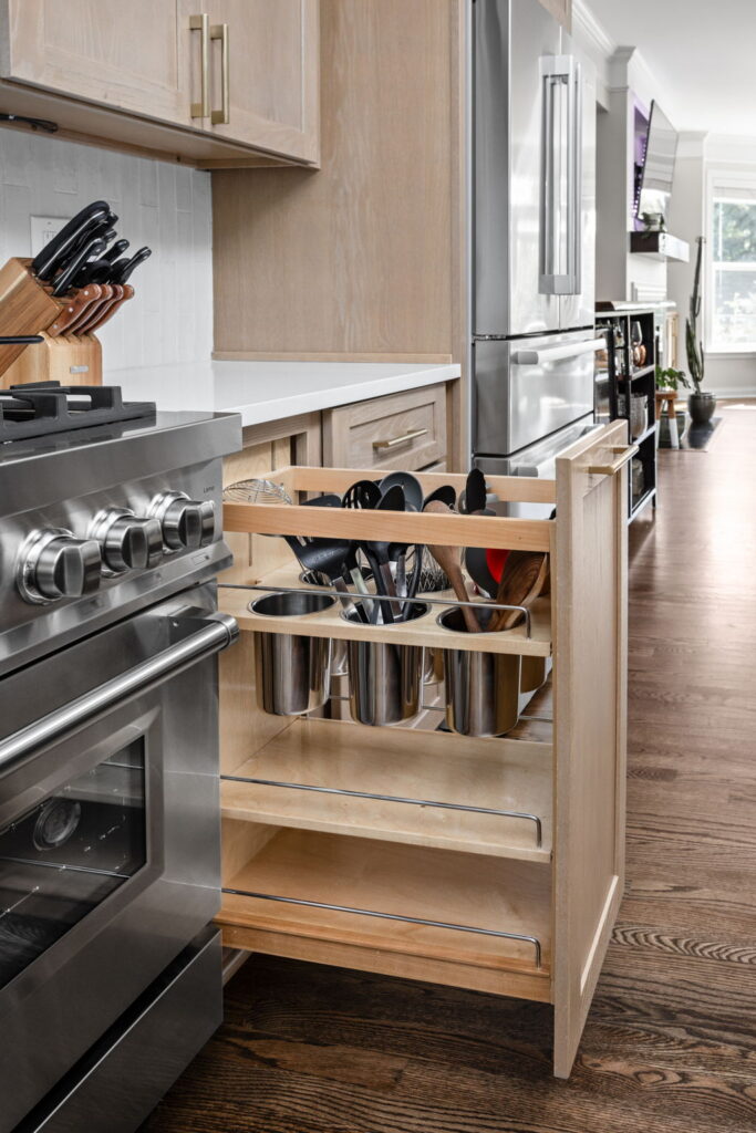 High end kitchen remodel Carmel with a custom pull out utensil organizer beside the range for cooking tools and kitchen storage.