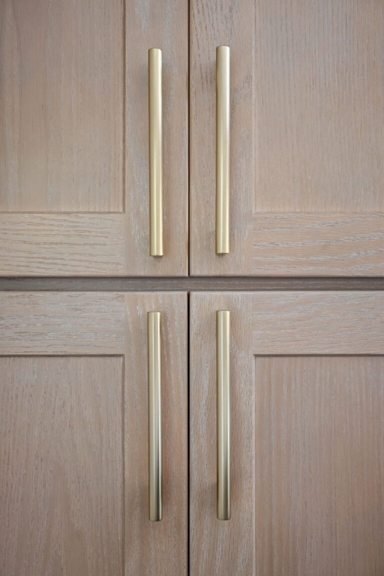 High end kitchen remodel Carmel with a close up of Golden Champagne cabinet hardware on light red oak wood shaker style cabinetry.