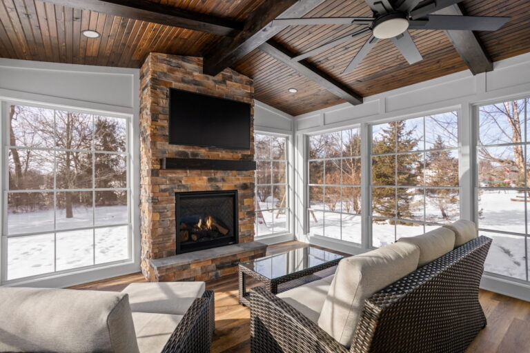 Home addition remodel Carmel IN sunroom fireplace wall with stone surround and vaulted wood ceiling.