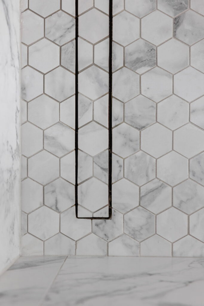 white marble hex tile shower floor with linear drain