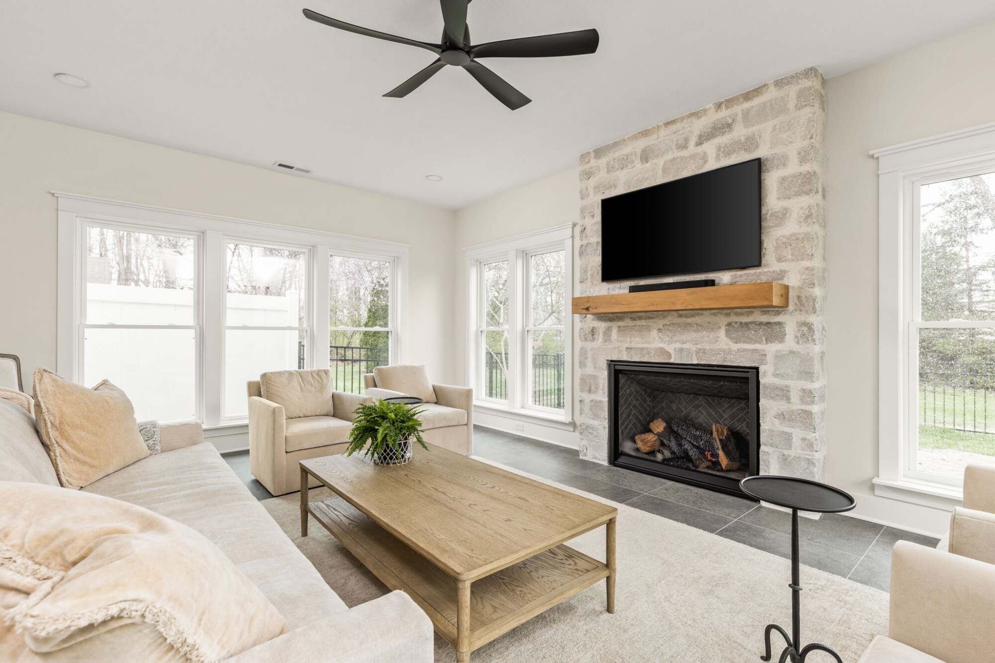 Finished Carmel sunroom addition with a Halquist Stone fireplace, large windows, and luxury home addition details by Worthington Design & Remodeling.