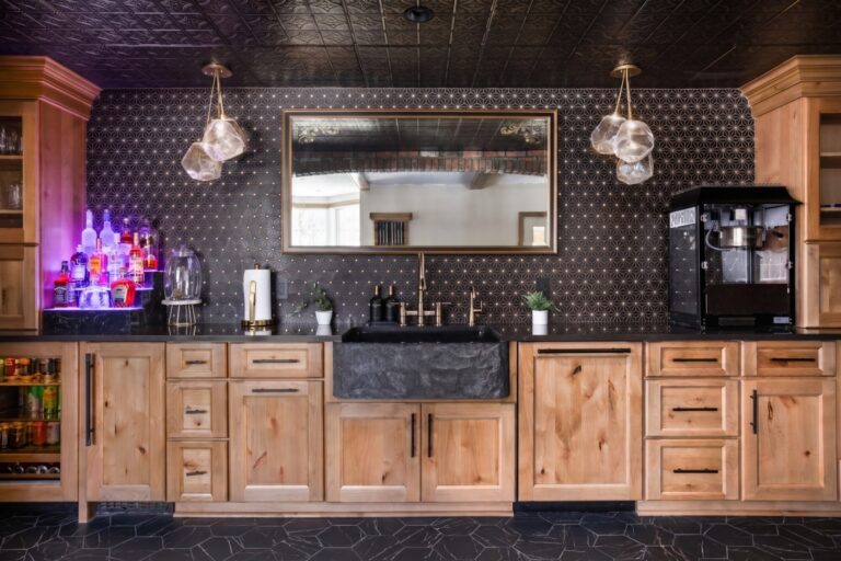 This showstopper luxury basement wet bar in Zionsville features custom Shiloh cabinetry with paneled appliances, a Signature Hardware farmhouse sink, and Cambria quartz.