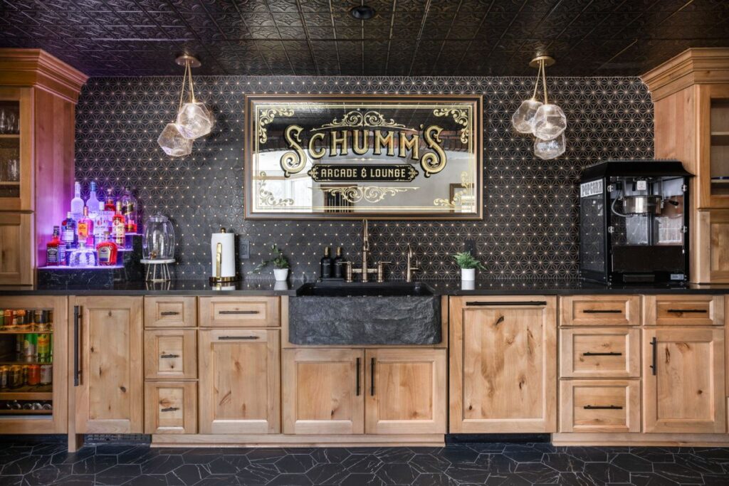 This showstopper luxury basement wet bar in Zionsville features custom Shiloh cabinetry with paneled appliances, a Signature Hardware farmhouse sink, and Cambria quartz.