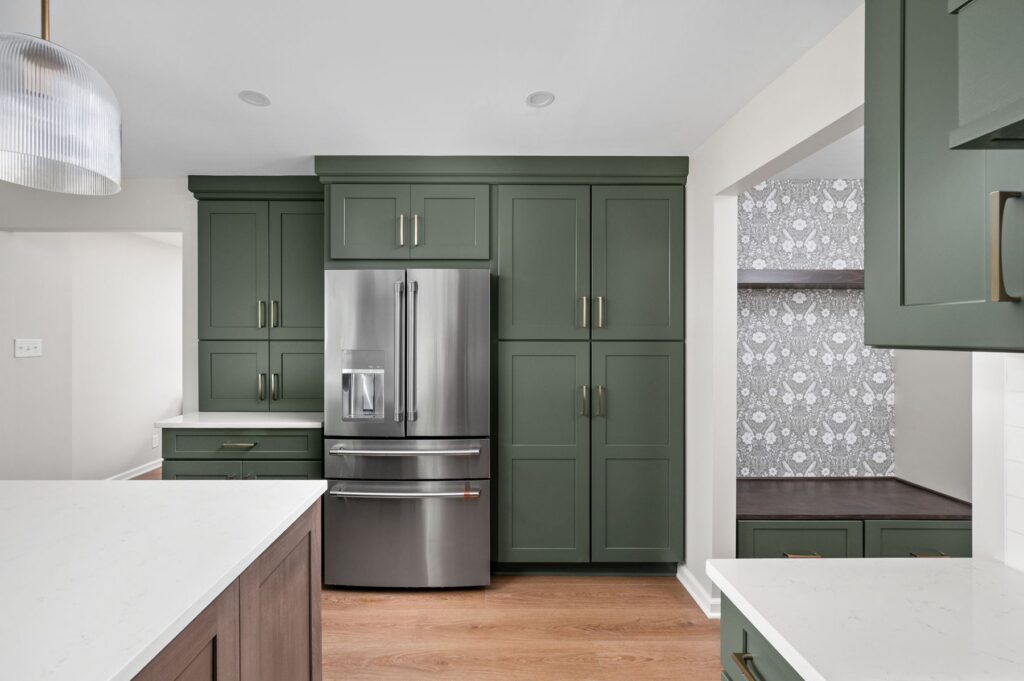 Finished Carmel kitchen remodel with tall Aspect maple Rosemary cabinetry, integrated refrigerator wall storage, MSI Quartz counters, and nearby mudroom cabinetry.