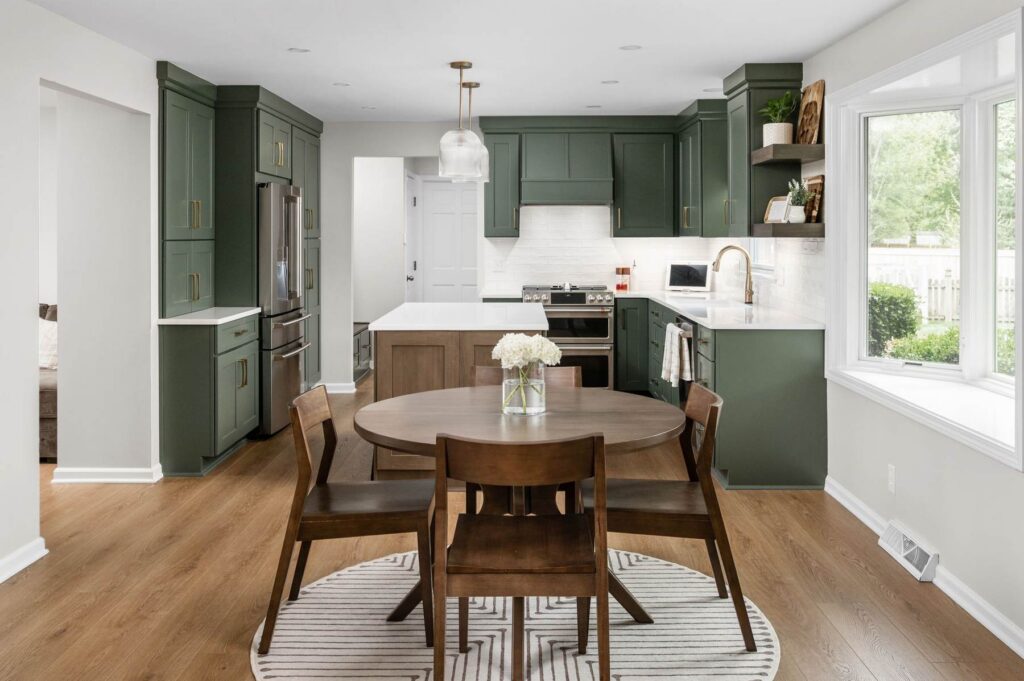 Finished luxury kitchen renovation in Carmel showing the open dining connection, Rosemary cabinetry, MSI Quartz countertops, and improved main level flow.