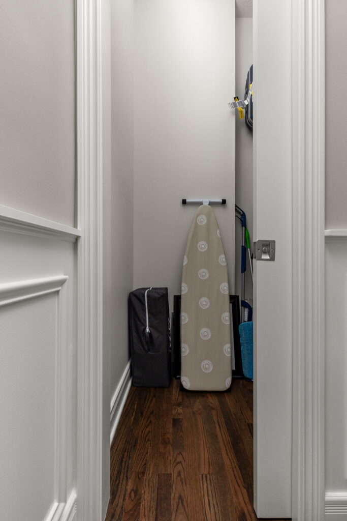 New storage closet in a Fishers multi-room remodel with space for an ironing board, cleaning tools, and household storage.