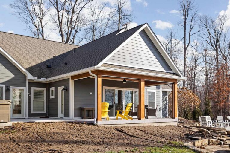 Backyard view of an Indianapolis sunroom addition and covered porch with cedar columns and expanded patio space.