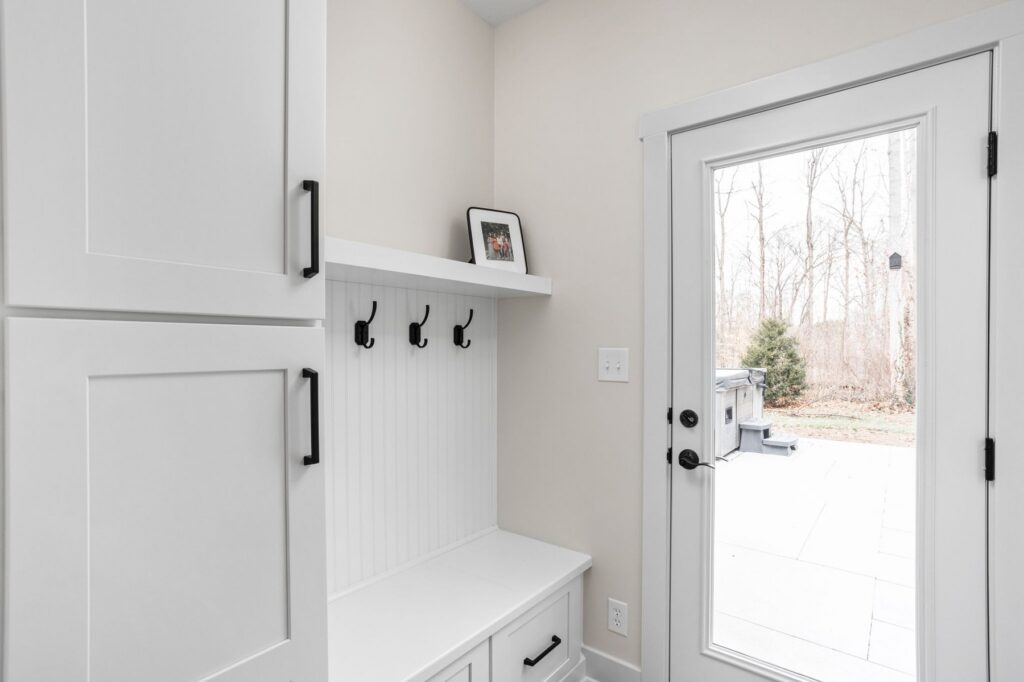 Glass entry door and built in bench storage in an Indianapolis sunroom addition and covered porch remodel.