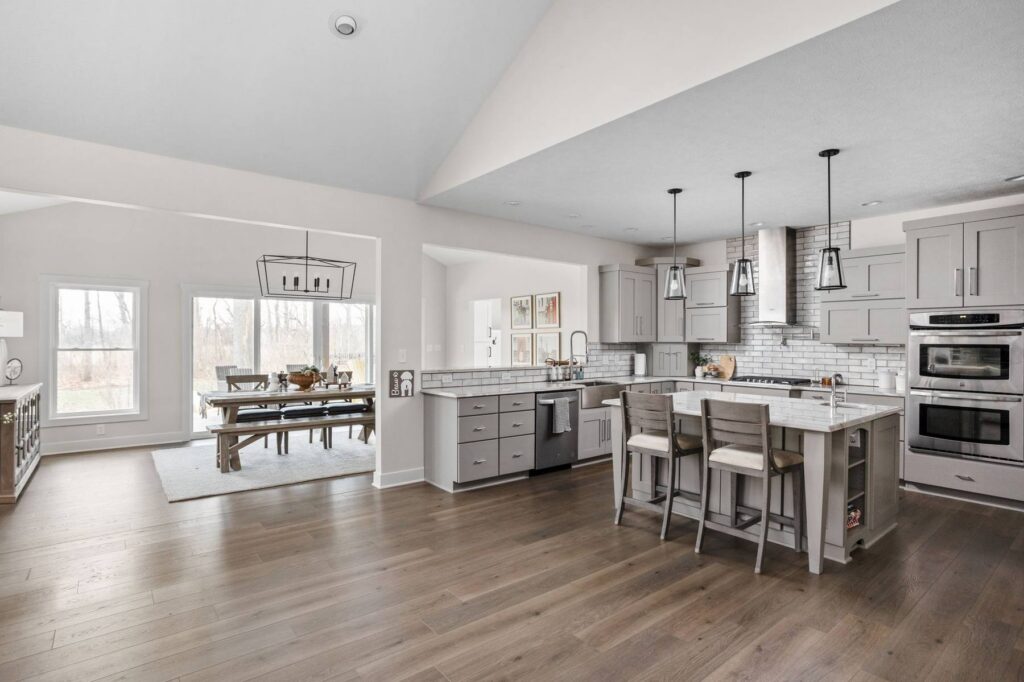Kitchen and sunroom connection in an Indianapolis remodel with Mont Blanc quartzite countertops and an open dining layout.