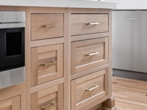 This luxury 2026 kitchen remodel in Carmel IN features warm wood Shiloh Cabinetry, a quartzite waterfall island, and curated collected details by Worthington Design & Remodeling.