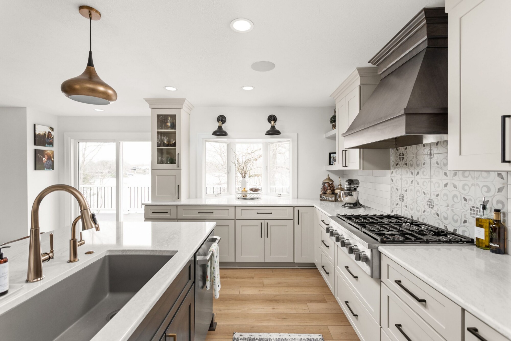 Fully renovated open concept kitchen and dining room in Indianapolis featuring a large quartz island and custom stacked white cabinetry.