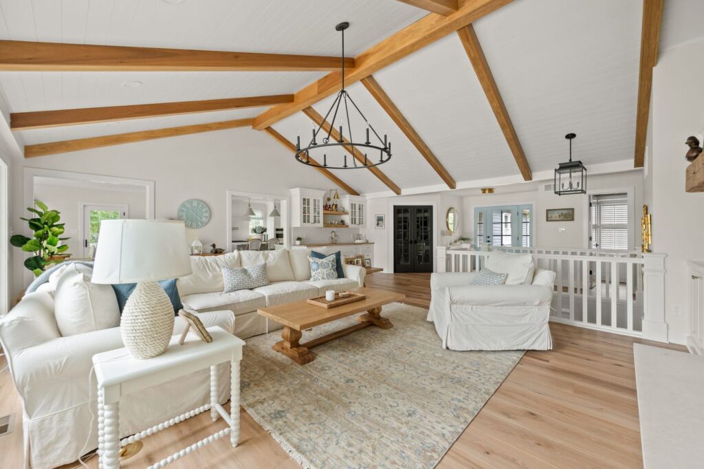 Living room in the Nantucket Bay whole-house remodel with vaulted ceiling, white oak beams, shiplap and open connection to the kitchen.