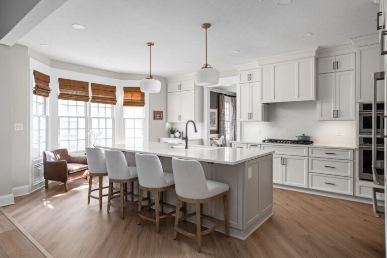 Finished Carmel kitchen with a large island, white perimeter cabinetry, contrasting island cabinetry and full-height built-in storage.