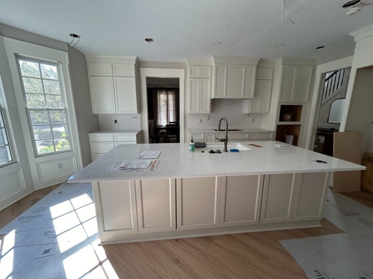 During construction: Large kitchen island with white quartz countertop and relocated sink in place.