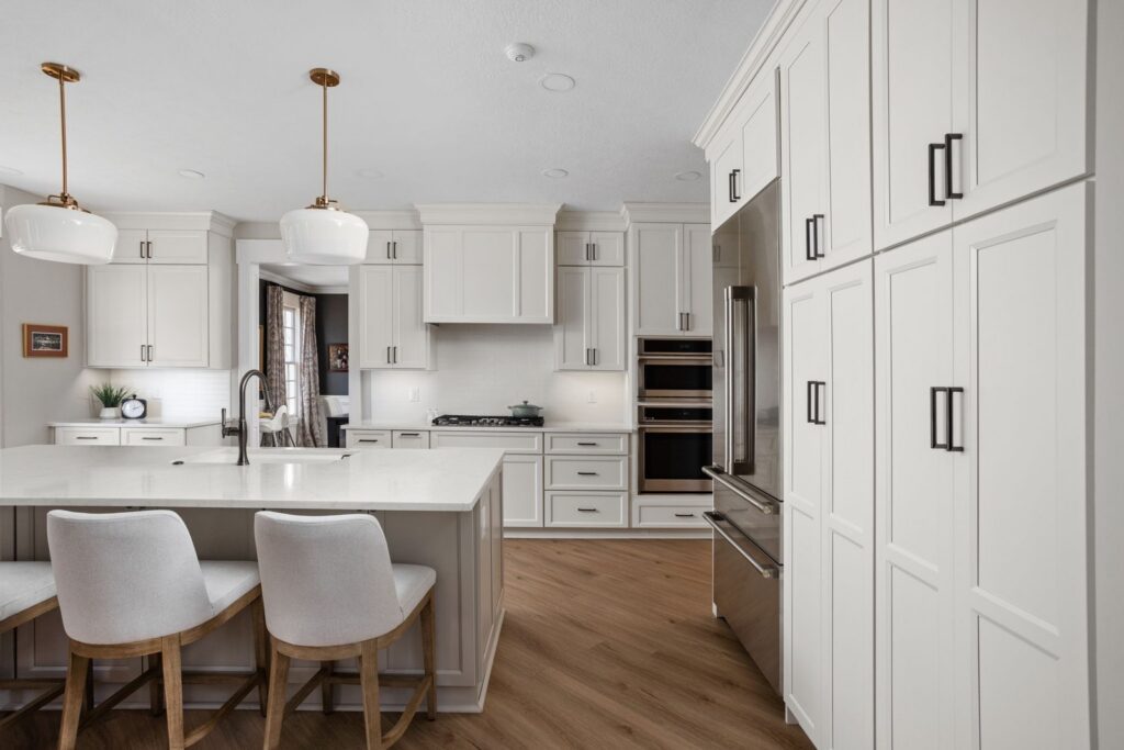 After: Carmel kitchen with full-height white cabinetry surrounding the refrigerator and appliance wall.