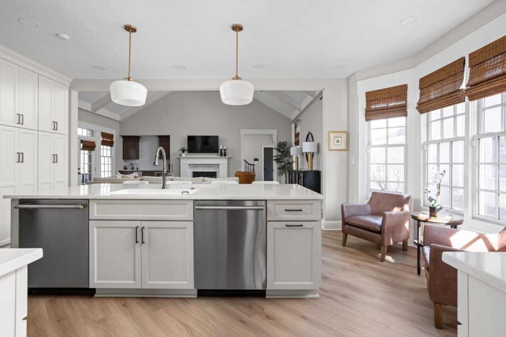 After: Working side of a large Carmel kitchen island with a sink, two dishwashers and cabinetry facing the living room.