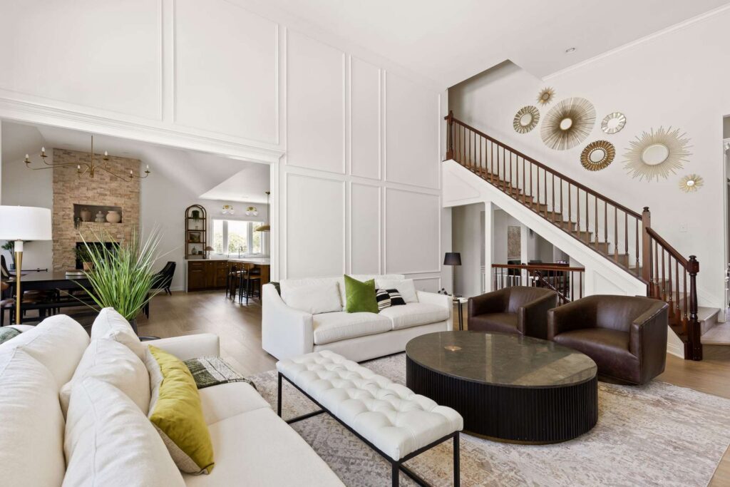 After: Carmel living room with a wide opening toward the kitchen and dining area, framed by white wall molding.