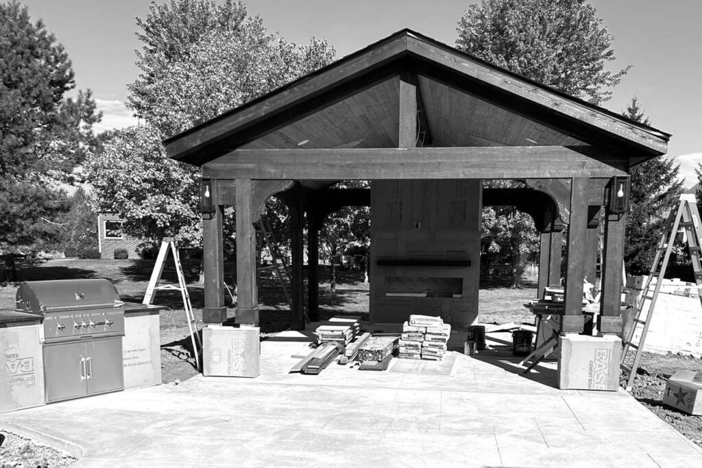 Pavilion during construction with exposed fireplace backer board, unfinished column bases and grill island.