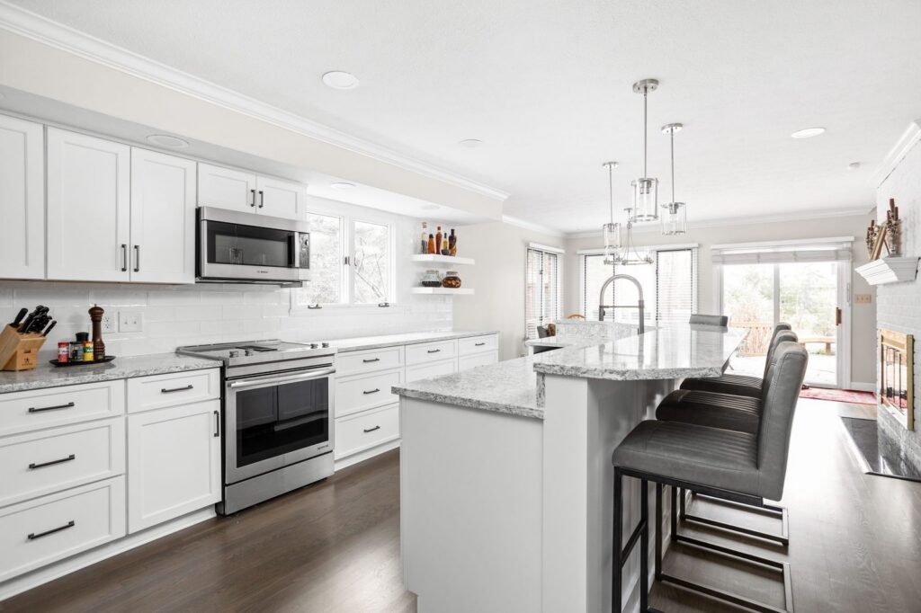 Expanded kitchen island in an Indianapolis home with seating, quartz countertops and white cabinetry.