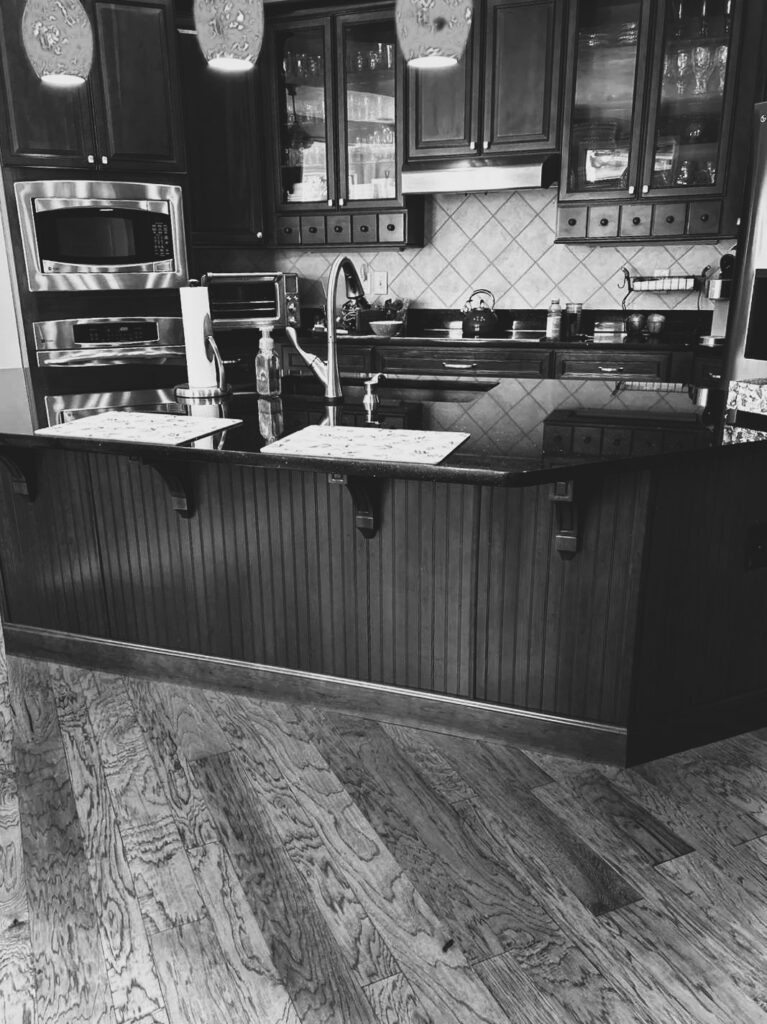 Before the makeover, this Westfield kitchen had stained cabinetry, dark countertops, beige tile flooring and a matching wood island.